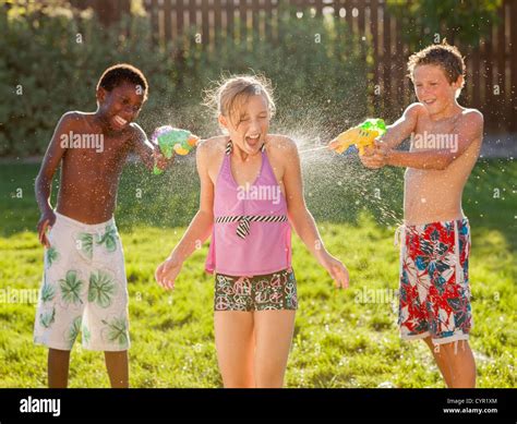 Boys Squirting Girl With Water Guns Stock Photo Alamy