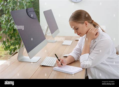 Young Woman Solving Sudoku Puzzle At Workplace In Office Stock Photo