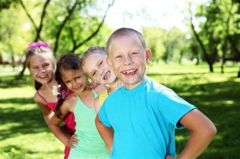 glückliche aktiv spielende kinder im sommer park stockfoto colourbox