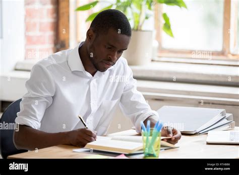 Serious African Man University Student Studying Reading Textbook Making