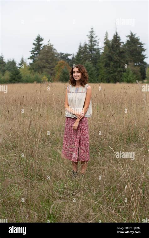 Portrait Of Happy Seventeen Year Old Girl Standing In Field Of Tall