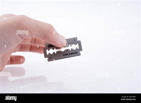 Hand Holding A Razor Blade On A White Background Stock Photo Alamy