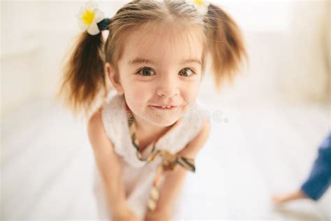 Cute Little Girl Looking At The Camera In Closeup And Smiling Funny
