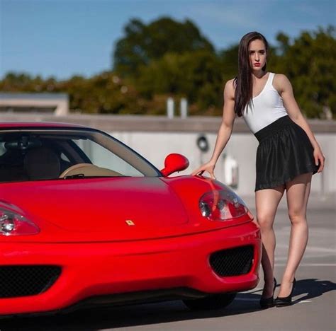 A Woman Standing Next To A Red Sports Car