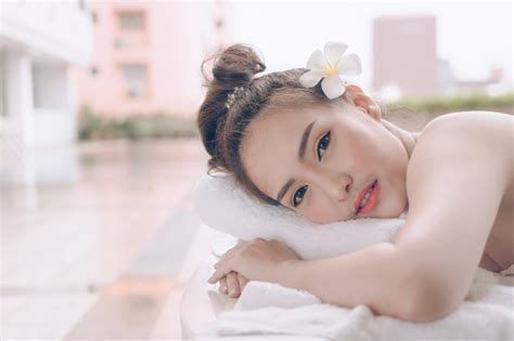 foto de linda mulher asiática relaxante com massagem mão no spa de beleza jovem feliz num salão