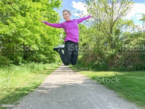 Joyful Young Woman Leaping In The Air Stock Photo Download Image Now