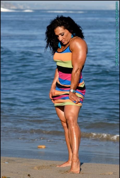 Brunette Bodybuilder Tonia Moore Flexes Her Muscles On A Beach In A Dress Nakedpics