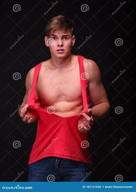 Handsome Young Man Tearing Shirt Off On A Black Background Fitness And