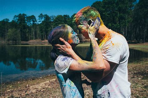 couple throwing colored holi powder at each other for fun del colaborador de stocksy michelle