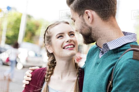 Portrait Of Happy Young Couple In Love Looking At Each Other On Street