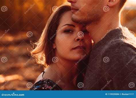 Guy And Girl In The Field On The Sunset Background Stock Photo Image