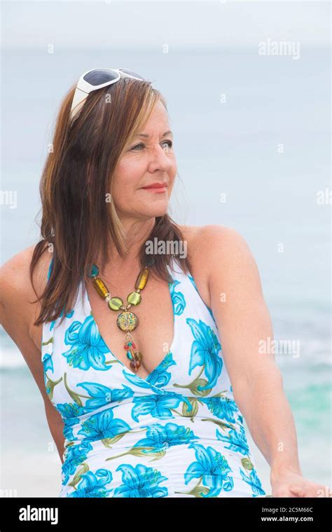 portrait confident attractive mature woman sitting alone outdoor with summer dress and