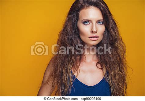 Close Up Portrait Of A Beautiful Tanned Young Woman With Curly Hair On
