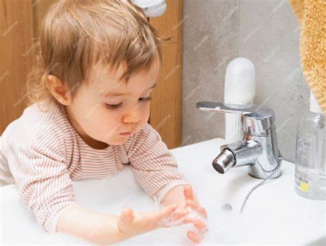 Premium Photo Child Washing Their Hands With Soap And Water In The