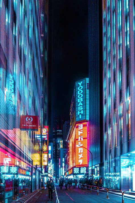 A City Street Filled With Tall Buildings And Neon Signs At Night All