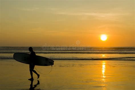 Silueta De Un Surfista Llevando Su Tabla De Surf En La Playa De Kuta Al