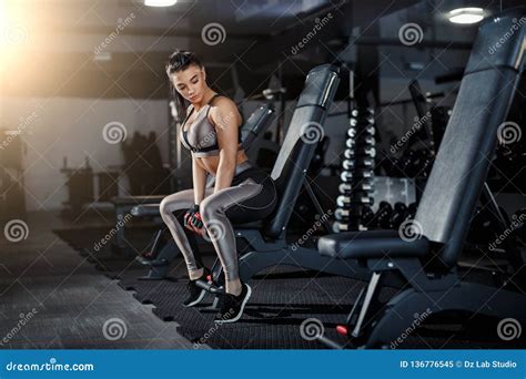 Slim Bodybuilder Girl Lifts Heavy Dumbbell Standing In Front Of The