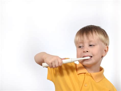 Premium Photo A Young Boy Brushing His Teeth With A Toothbrush