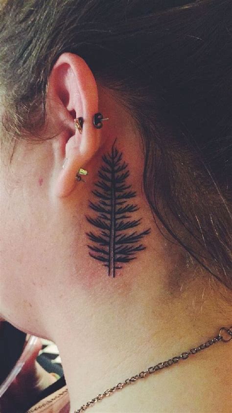 A Woman With A Tattoo On Her Neck And Behind The Ear Is A Pine Tree