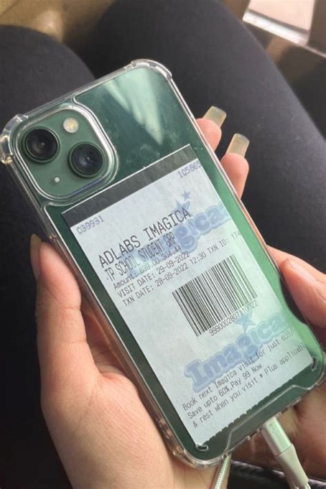 A Person Holding An Iphone Case With A Ticket Attached To The Back And