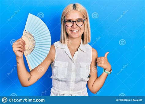Beautiful Blonde Woman Waving Hand Fan Cooling Air In Summer Smiling