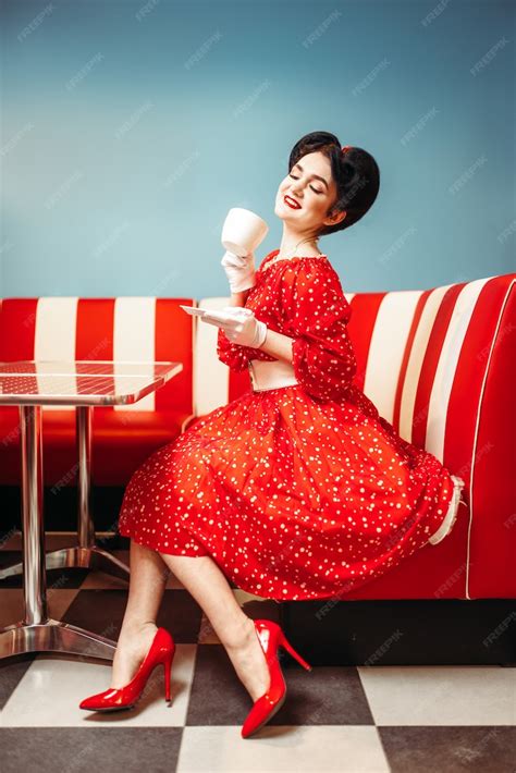 premium photo pretty pin up girl with make up drinks coffee in retro cafe 50 american fashion