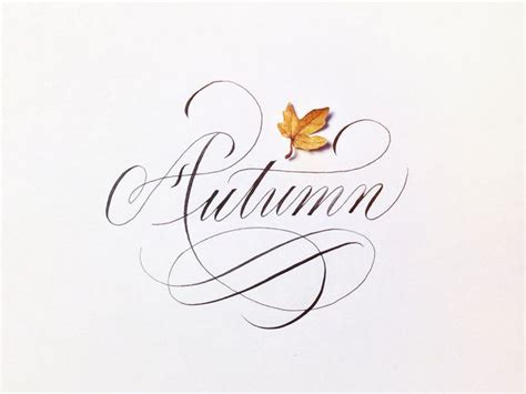 The Word Autumn Written In Cursive Calligraphy With An Orange Leaf On It