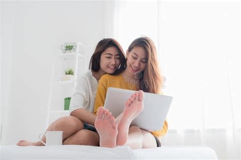 Asian Lesbian Lgbt Couple Sitting On Bed Hug And Using Laptop Co Stock Image Image Of