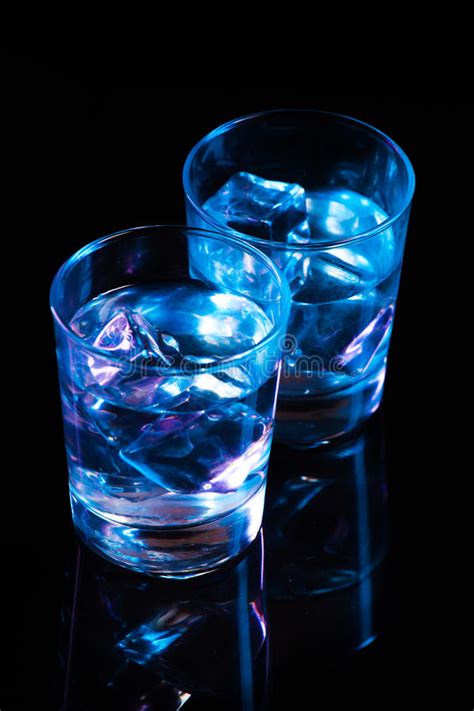 Two Glasses With Vodka And Ice Cubes Against The Background Of Deep