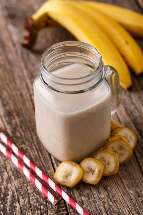Healthy Banana Smoothie In Glass Jar With Bananas On Wooden Table