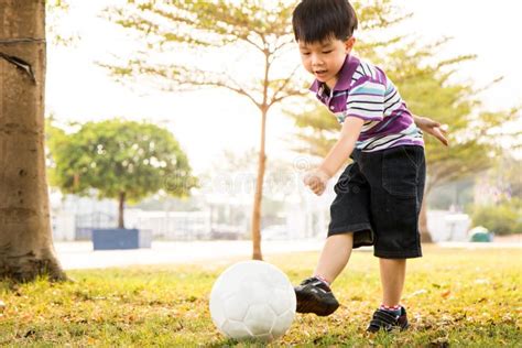 Boy Learning Kick Ball At The Park In The Evening Stock Photo Image