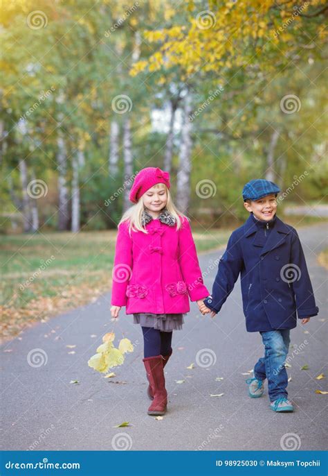 Children Walking In Beautiful Autumn Park On Warm Sunny Fall Day Stock