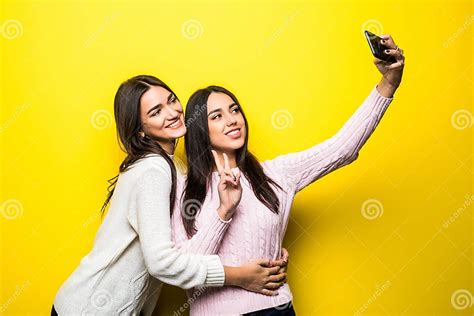 Portrait Of Two Lovely Girls Dressed In Sweaters Standing And Taking A