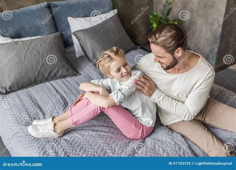 Adorable Daughter And Father Sitting On Bed At Home Stock Image Image