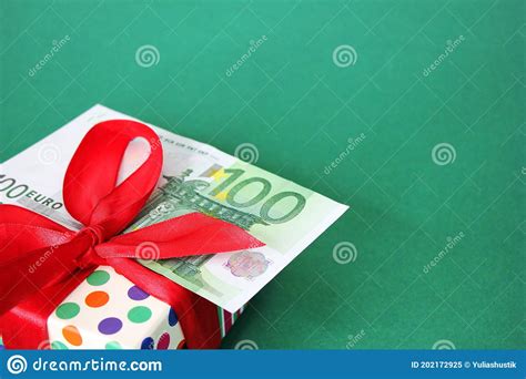 100 Euro Banknote On A T Box With A Red Bow Green Background Stock