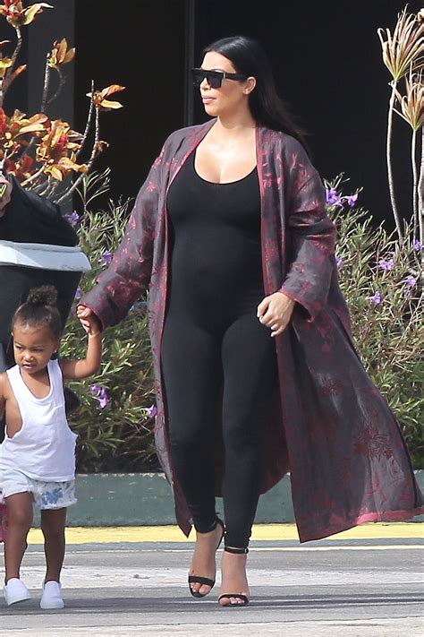 kim kardashian leaving st barth s in a black bodysuit and kimono style jacket with daughter