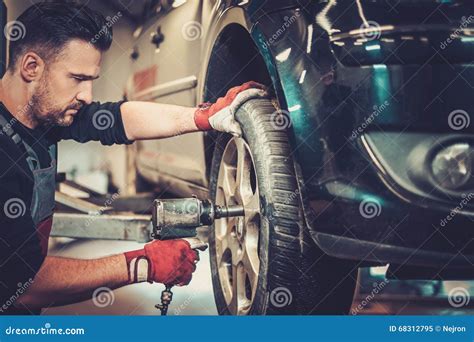 Car Mechanic Changing Car Wheel In Auto Repair Service Stock Image Image Of Machinist