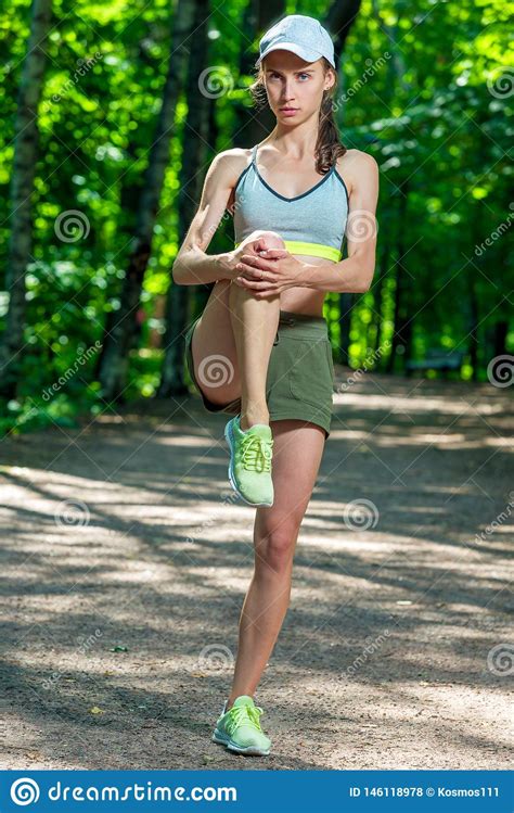 Slim Muscular Athletic Girl Warms Up Her Muscles Before Jogging Stock