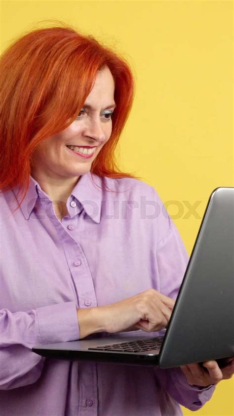 redheaded mature woman smiling while using a laptop stock video colourbox