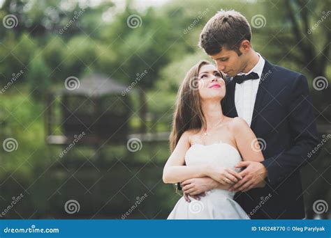 Beautiful Couple Posing In Park Honeymoon Newlywed In Love Holding