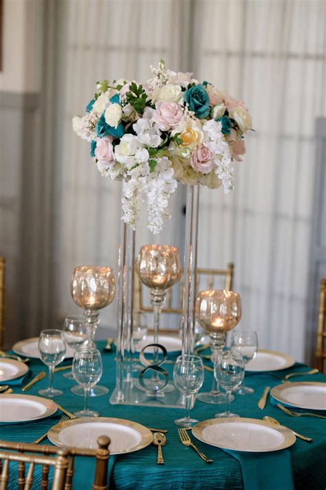 Incorporate gold seamlessly into the space through details like your wall decor and light fixtures. Teal and Rose Gold | Rose wedding, Wedding centerpieces, Wedding planning