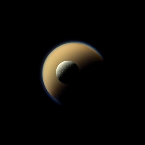 Saturns Two Largest Moons Titan And Rhea Pass By Each Other In This