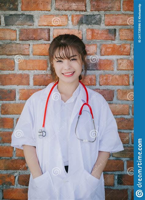 Portrait Of Happy Young Female Doctor Standing And Smiling Stock Photo
