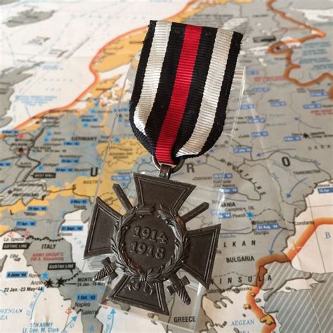 A Medal On Top Of A Map With A Red White And Black Ribbon