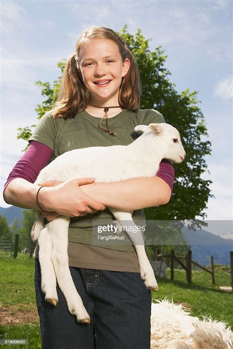 Girl Carrying Lamb On Farm Photo Getty Images