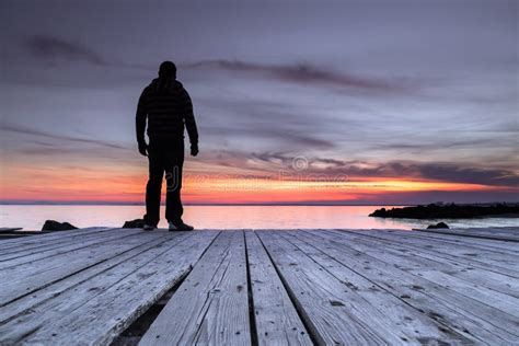 Man Sitting On The Pier And Watching The Sunset Stock Image Image Of