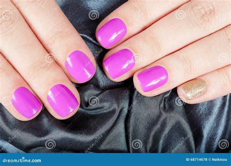 Hands With Manicured Nails Covered With Pink And Gold Nail Polish Stock