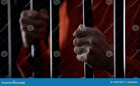 Hands of Desperate Arrested Male Holding Prison Bars, Unfair Judgment