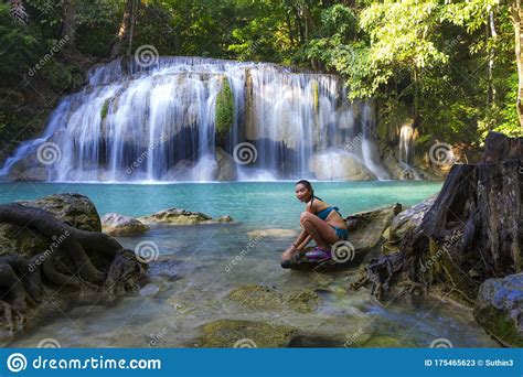 Traveler In Blue Swimsuit Sit Relax At Erawan Waterfall Stock Image