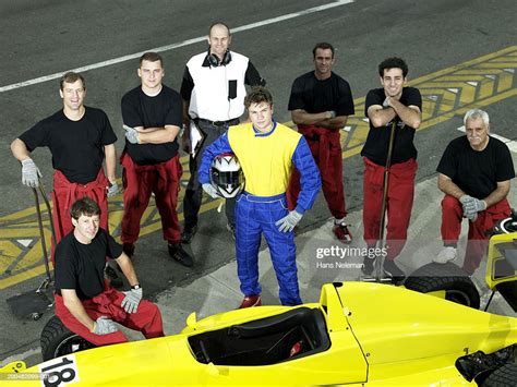 Driver And Pit Crew With Formula 1 Race Car Elevated View Portrait High